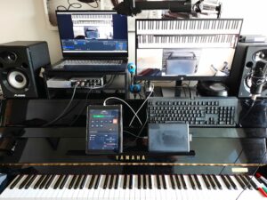 Online piano lesson setup with keyboard, displays and microphone